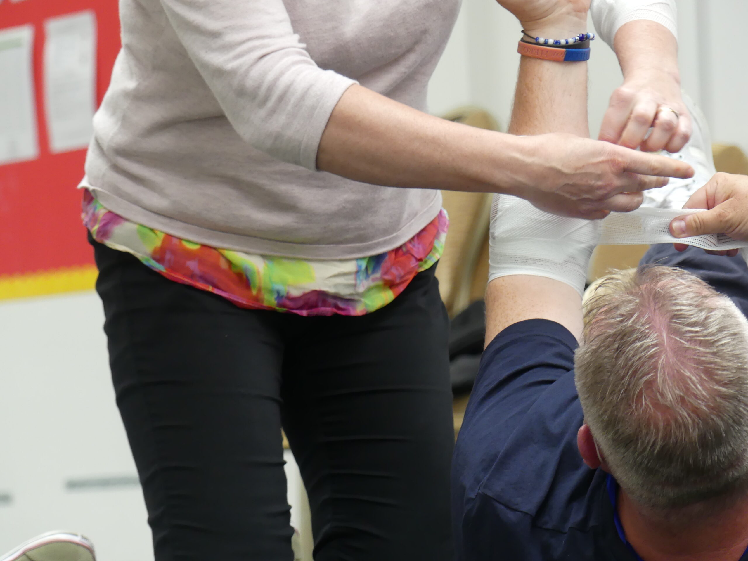 Learner practicing an arm dressing on a first aid course