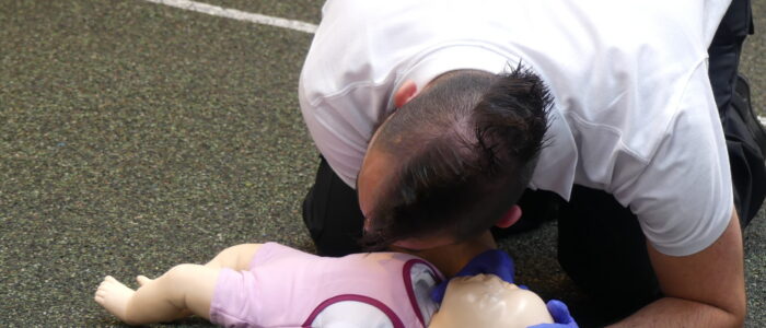 Demonstrating checking infant breathing on Emergency Paediatric First Aid Course