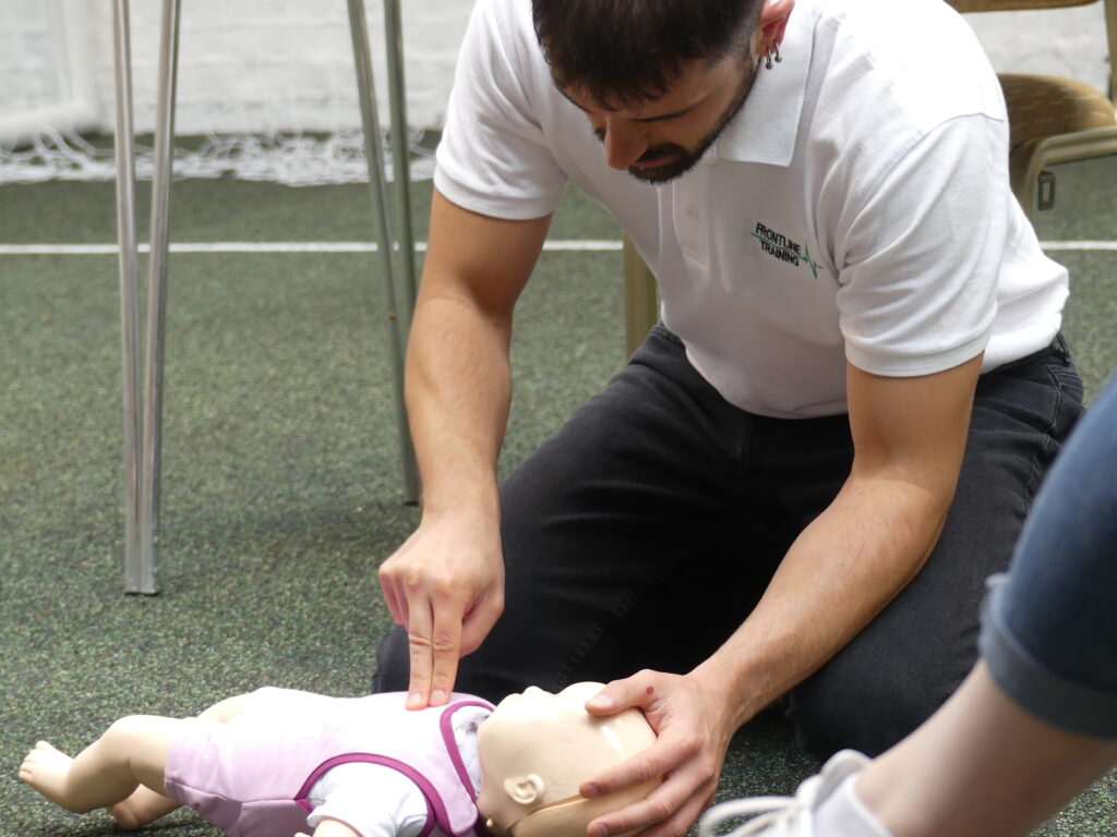 Frontline Training Instructor demonstrating CPR on an infant