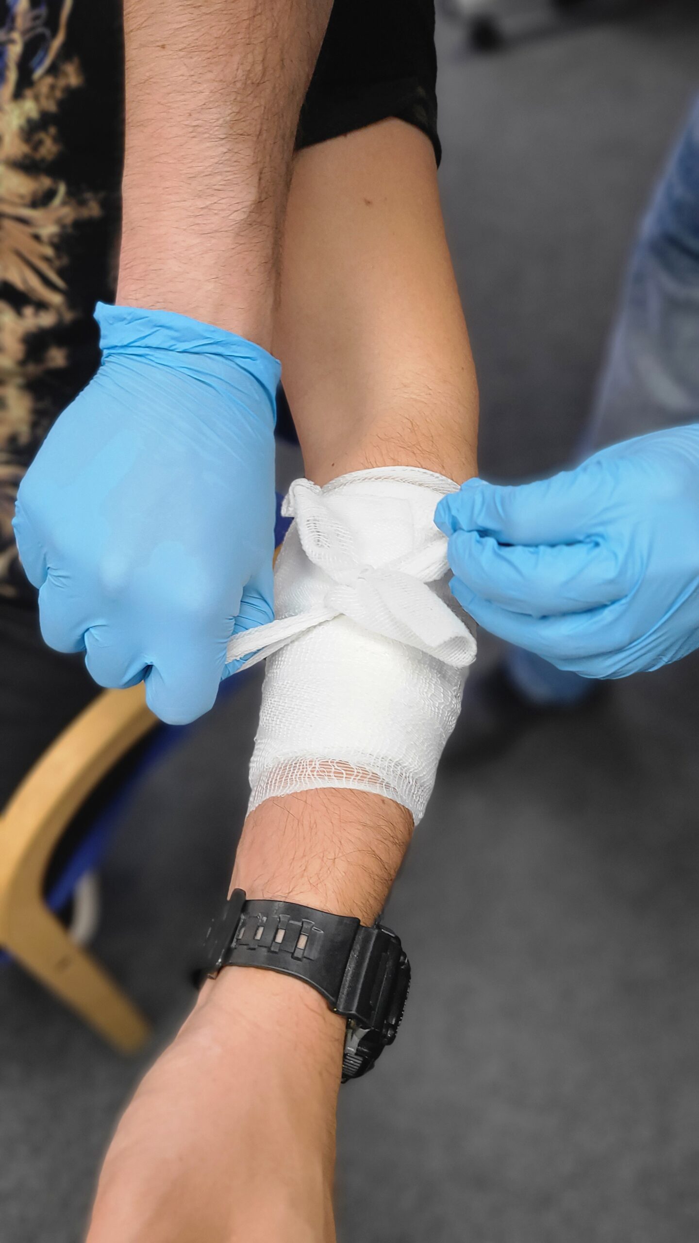 First aid training on dressing an arm wound