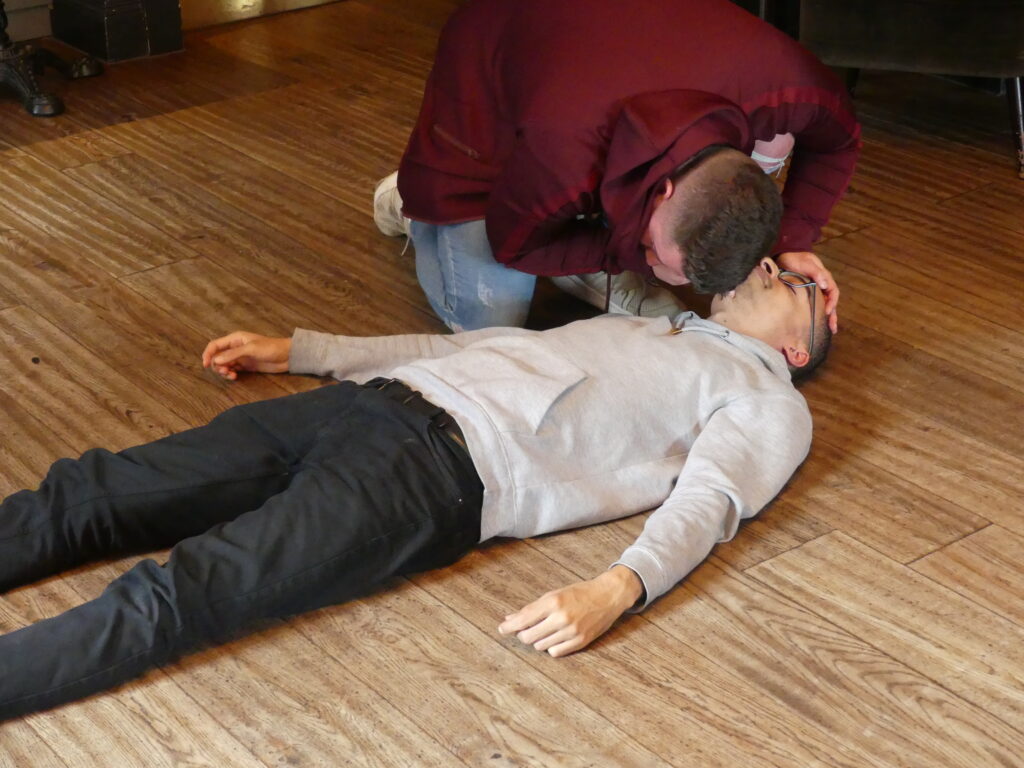 A first aider checking on a fainting casualty
