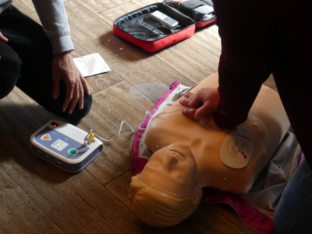 Learners practicing CPR and using a training defibrillator