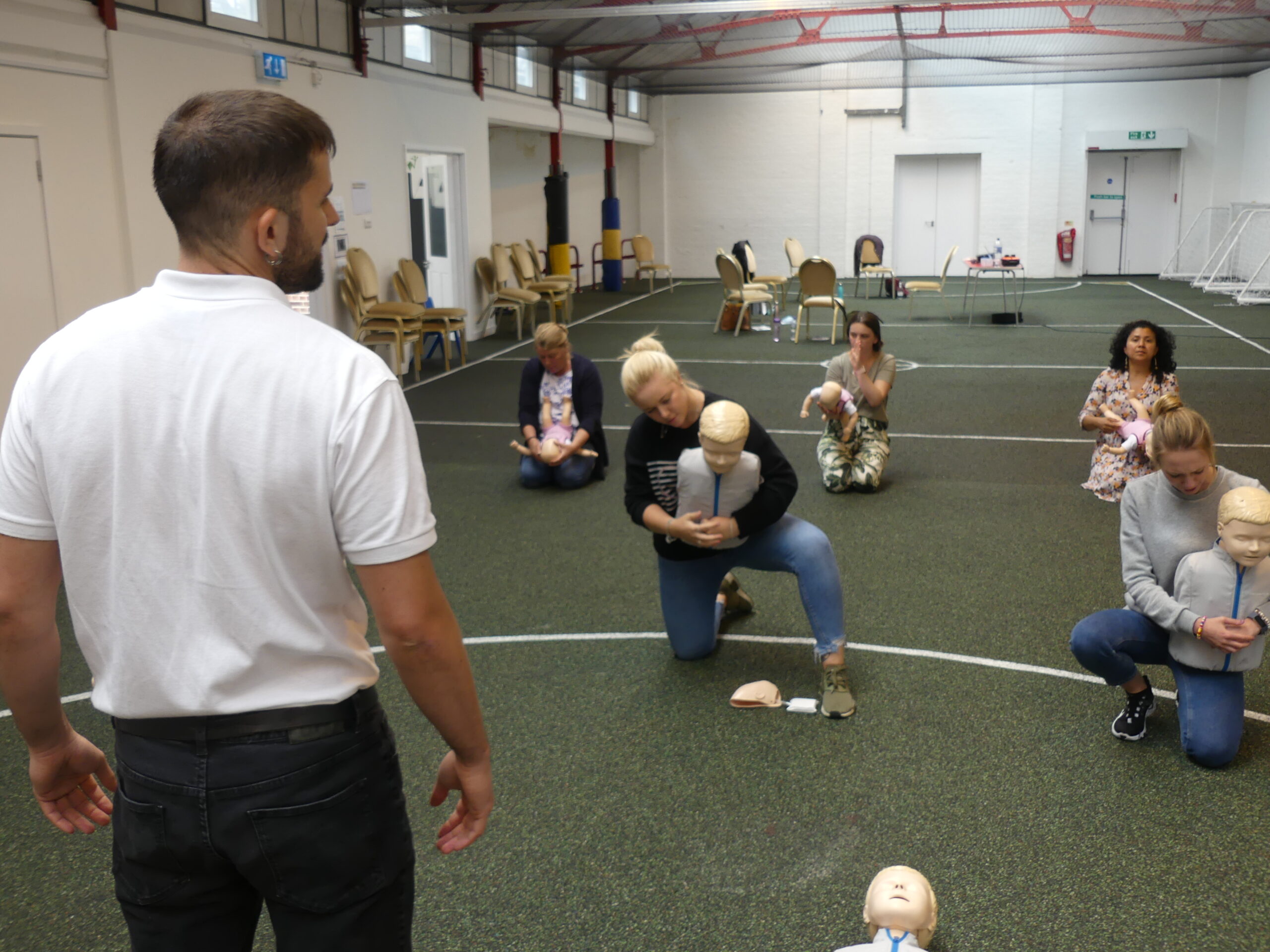 Group practicing choking on a paediatric first aid course